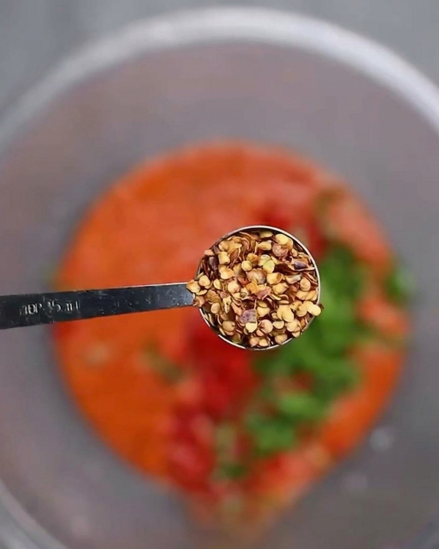 Graines de piment ajoutées à la pâte rouge et aux légumes frais hachés.