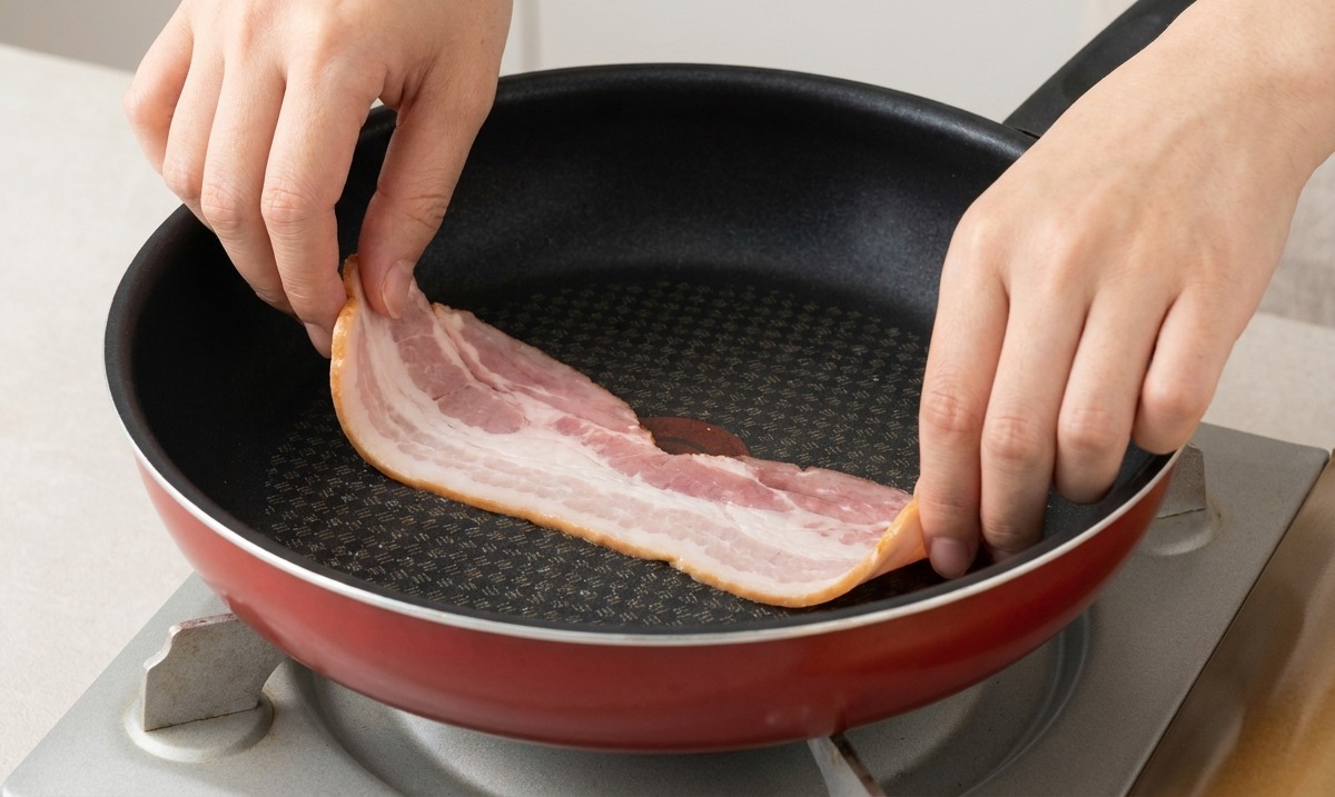 Dépose de tranches de bacon dans une poêle chaude légèrement huilée.