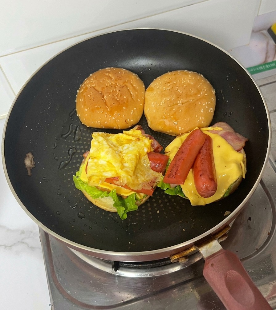 Le burger assemblé dans la poêle montrant toutes ses couches savoureuses.