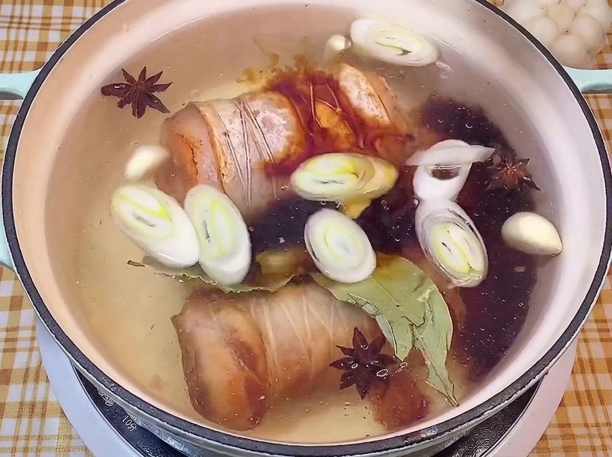 Ajout de sauce soja foncée dans une marmite avec les rouleaux de porc et les épices.