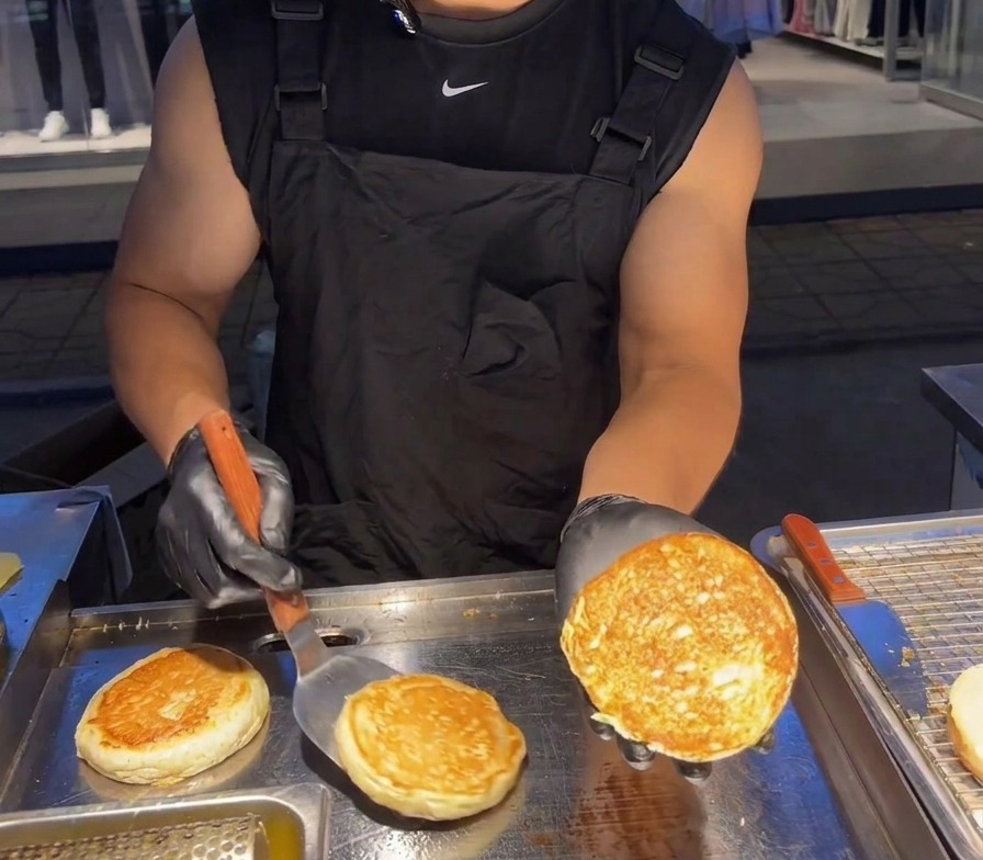 Une personne montrant la face interne dun pain burger parfaitement dorée et croustillante.