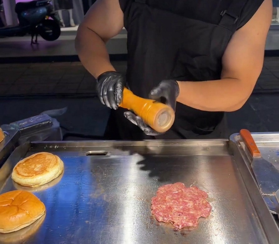 Du sel de mer frais moulu sur le dessus dun steak de bœuf aplati sur une plaque professionnelle.