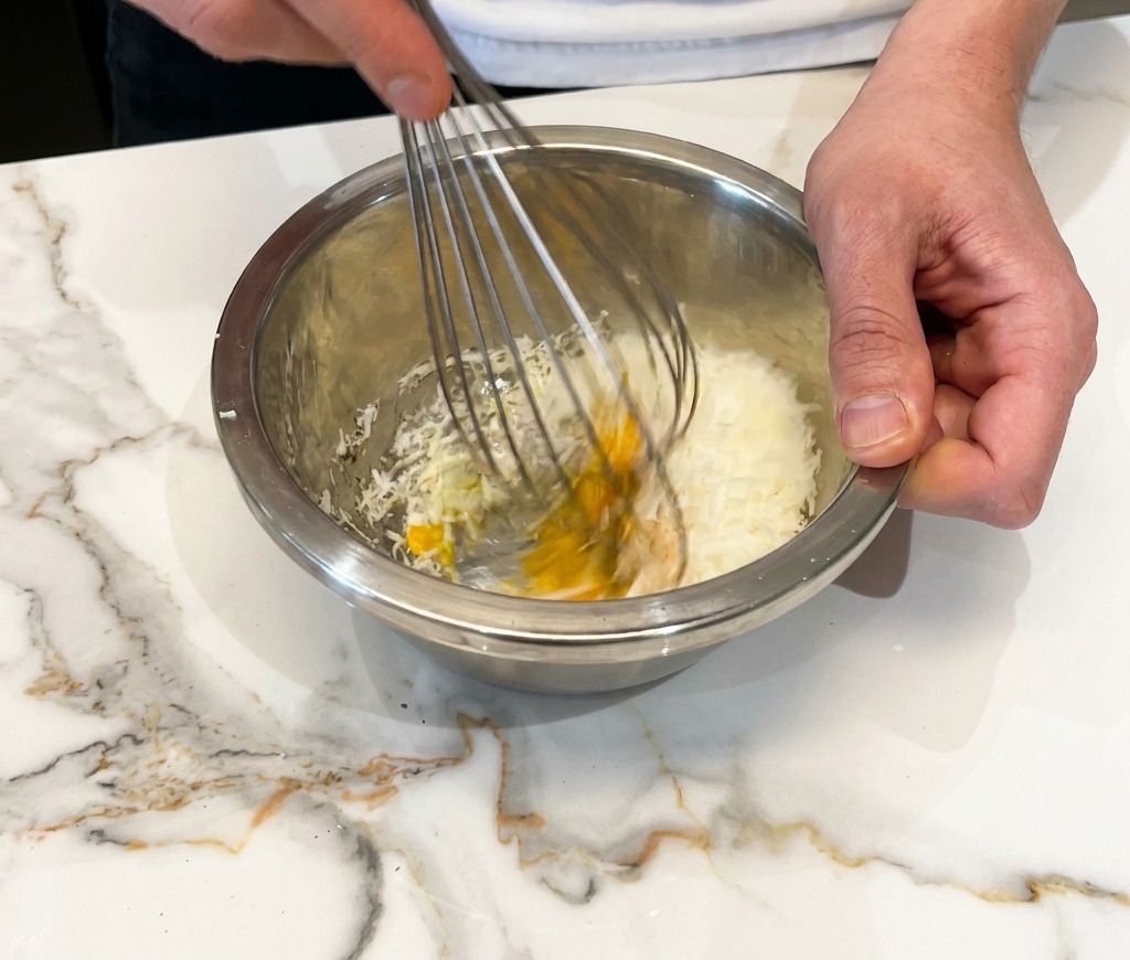 Mélange vigoureux de lœuf, du fromage et du poivre pour obtenir une crème épaisse.