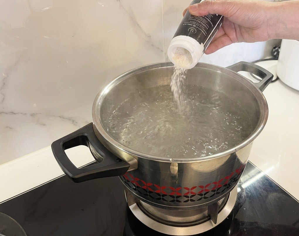 Sel blanc versé dans une casserole deau bouillante à gros bouillons.