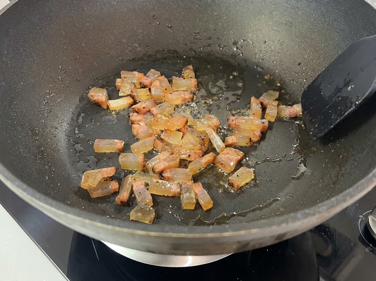 Dés de guanciale rissolant dans leur propre gras et devenant dorés.