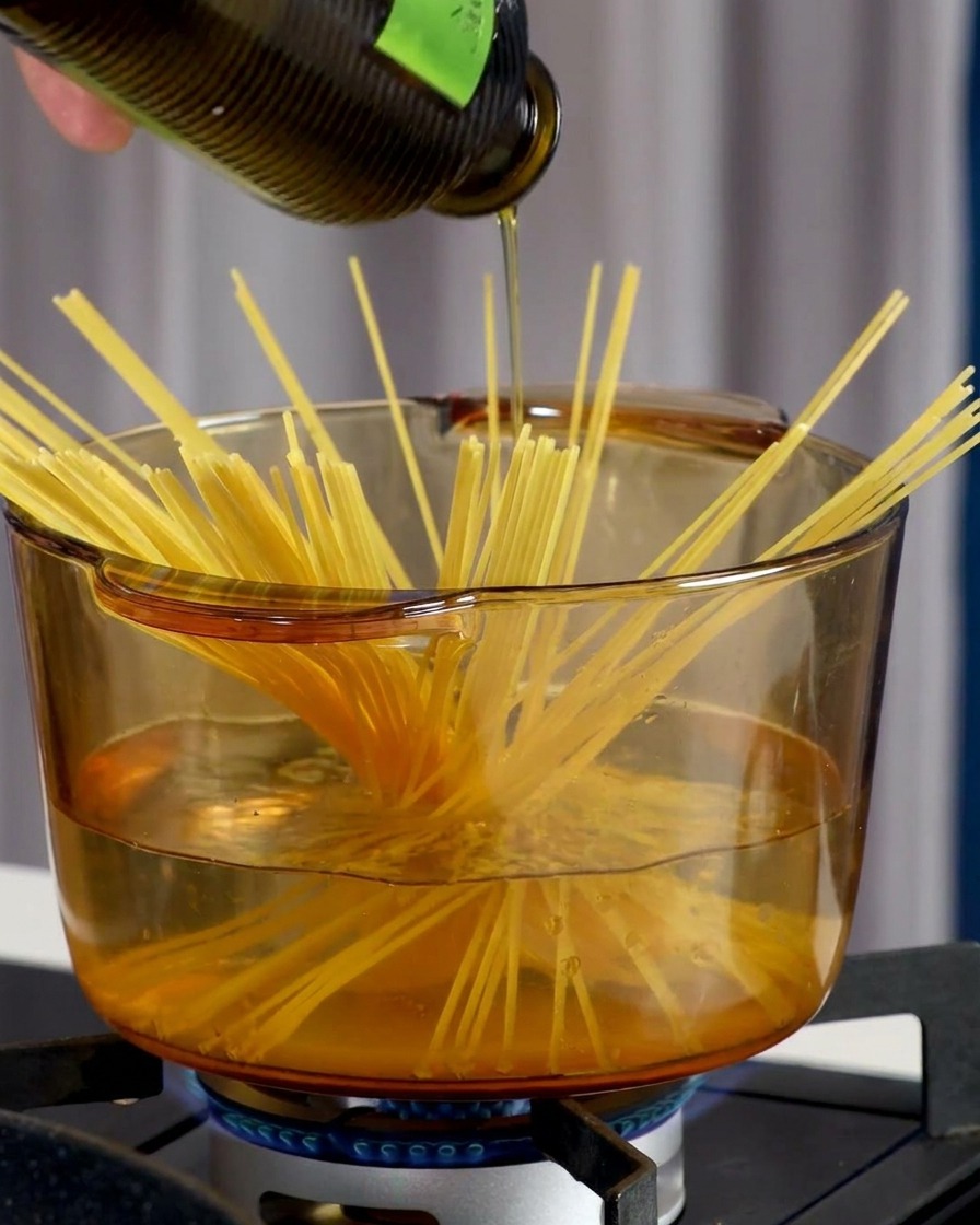 Une main saupoudrant du sel de mer dans une casserole deau bouillante contenant des spaghettis.