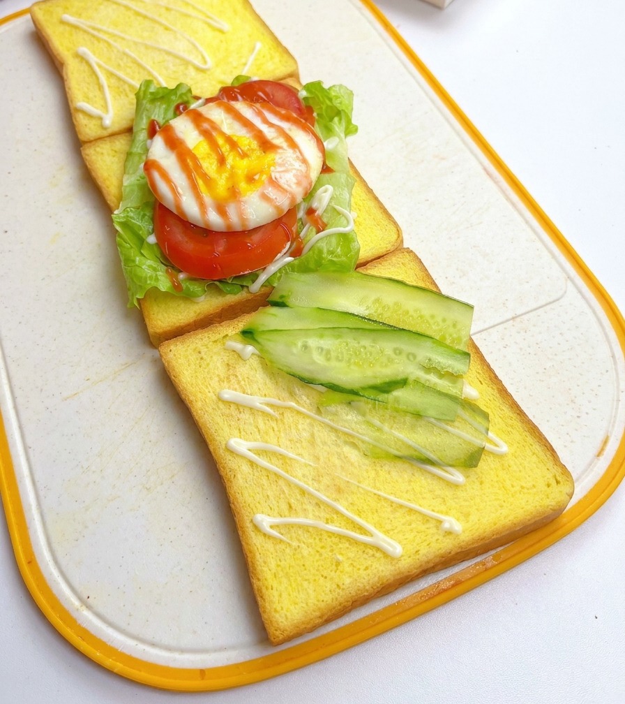 Tranches de concombre disposées en diagonale sur une deuxième tranche de pain de mie.
