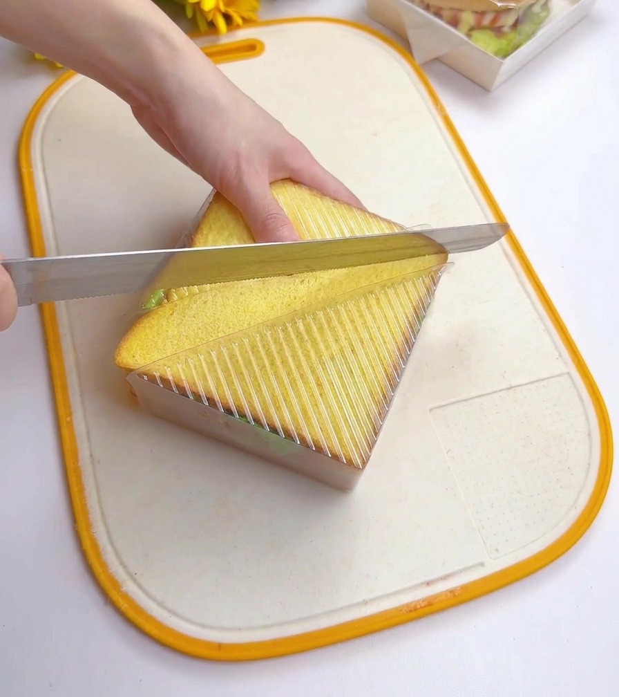 Utilisation dun couteau à pain pour couper le sandwich en diagonale dans son moule.