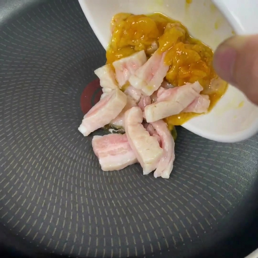 Gras de poulet et de porc crus versés dans une poêle froide.