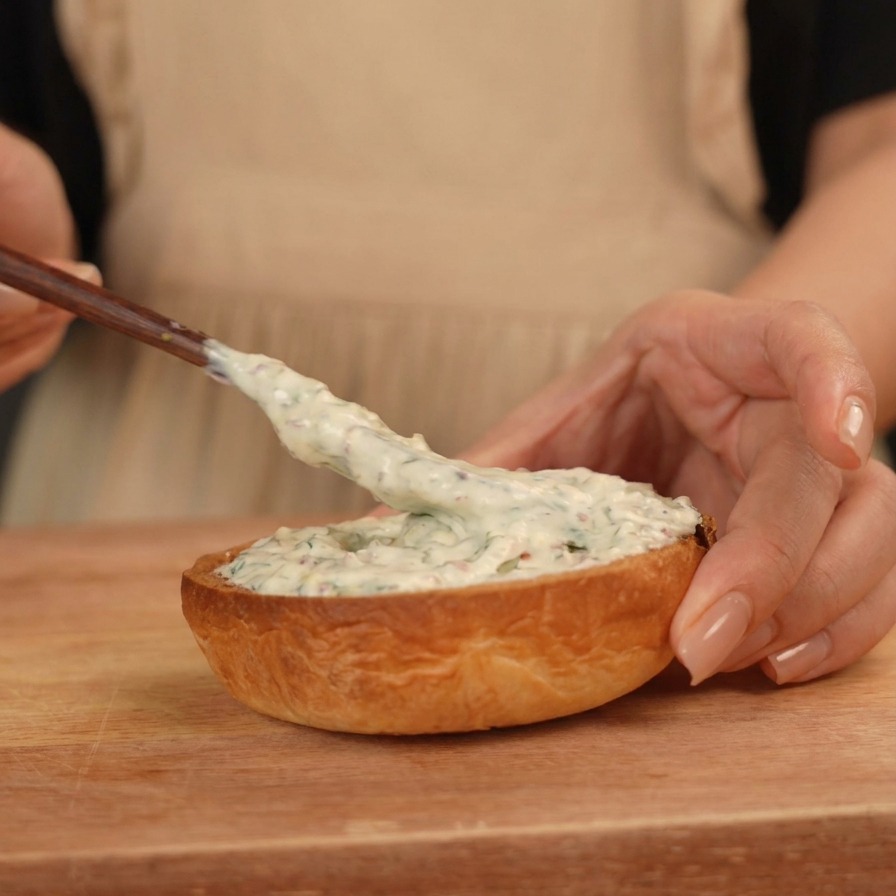 Étaler une sauce blanche crémeuse sur la moitié inférieure dun pain burger brioché toasté.