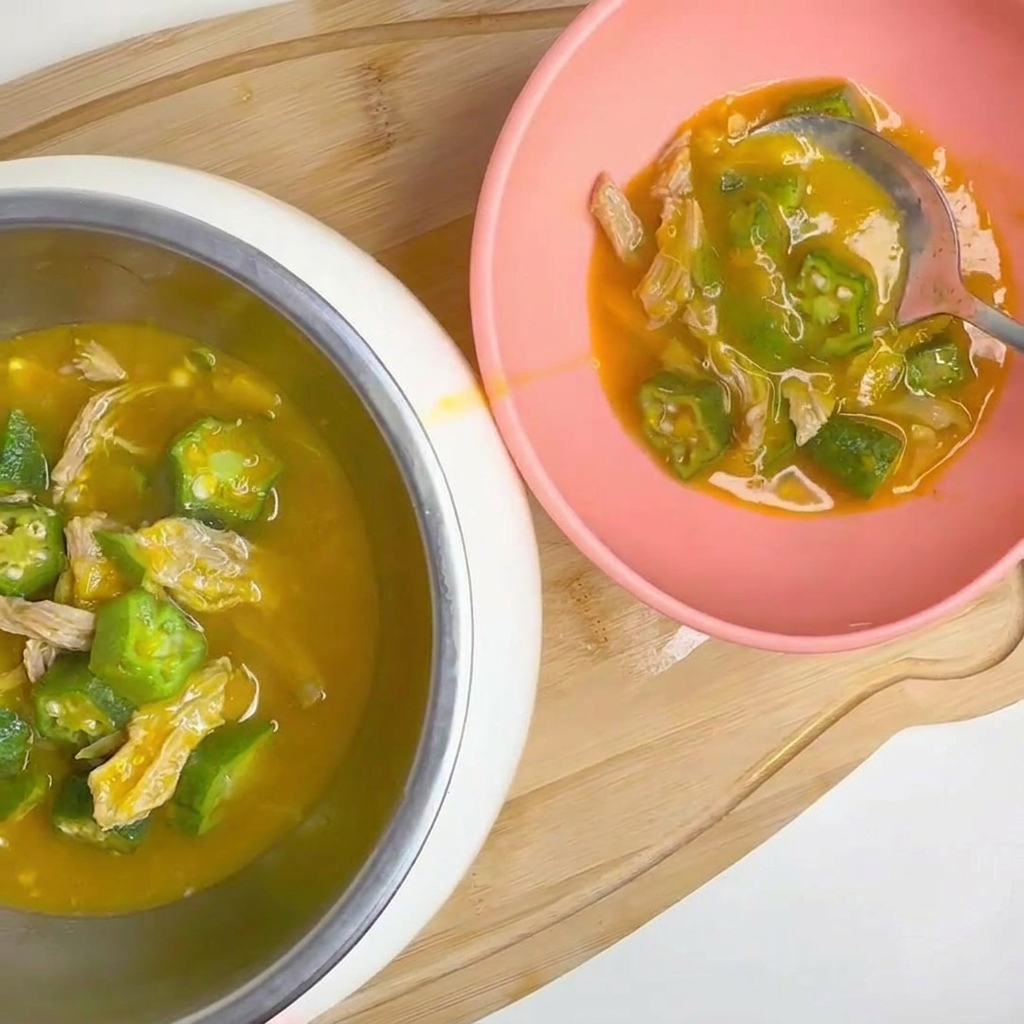 Des gousses de gombo vert frais rincées sous un filet deau.