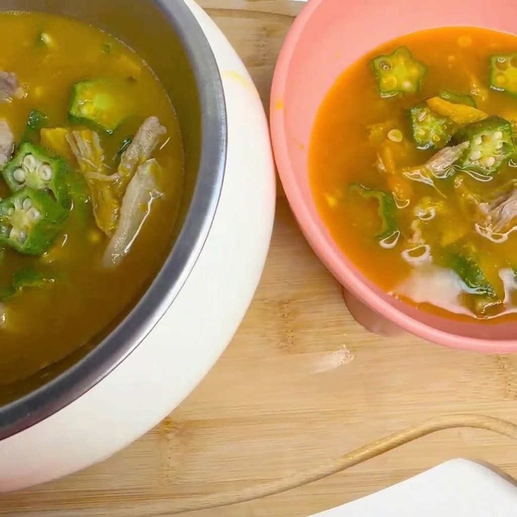 Une louche remuant délicatement la soupe de gombo et canard qui mijote.