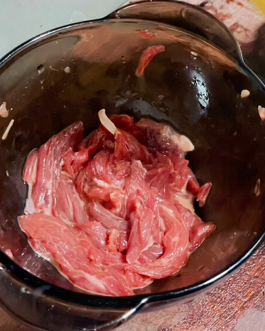 Un filet dhuile ajouté sur le bœuf mariné.
