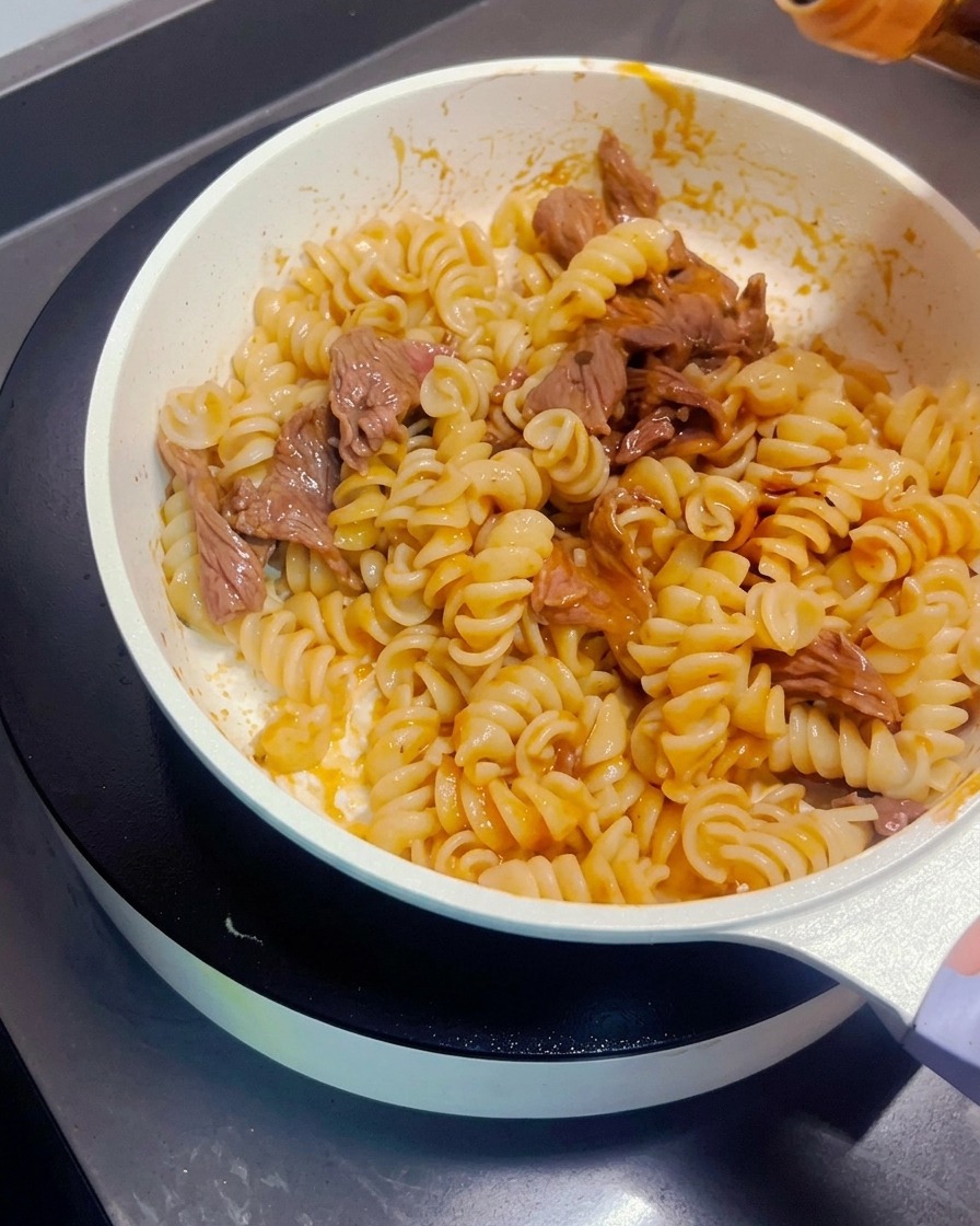 Sauce soja noire versée sur les pâtes sautées au bœuf.