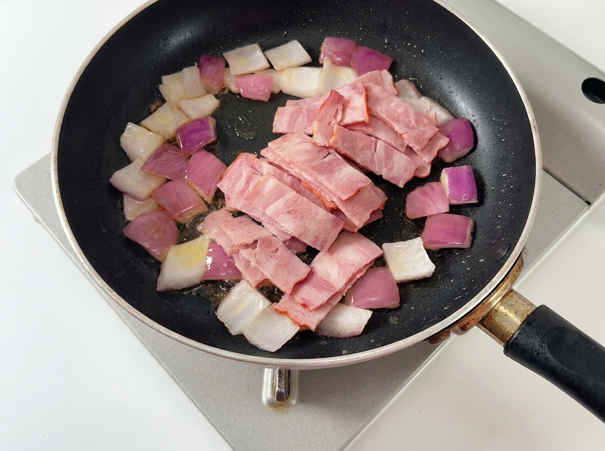 Dés doignons, lardons et tranches de champignons cuisant ensemble dans une poêle beurrée.
