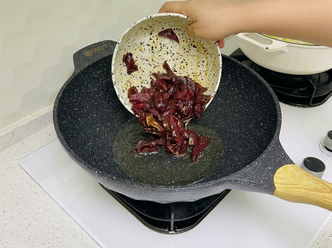 Lanières de bœuf mariné en train de grésiller dans un wok chaud.