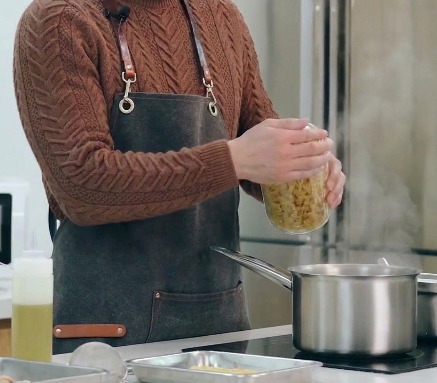 Des pâtes torsadées crues versées dans une grande casserole deau bouillante salée.