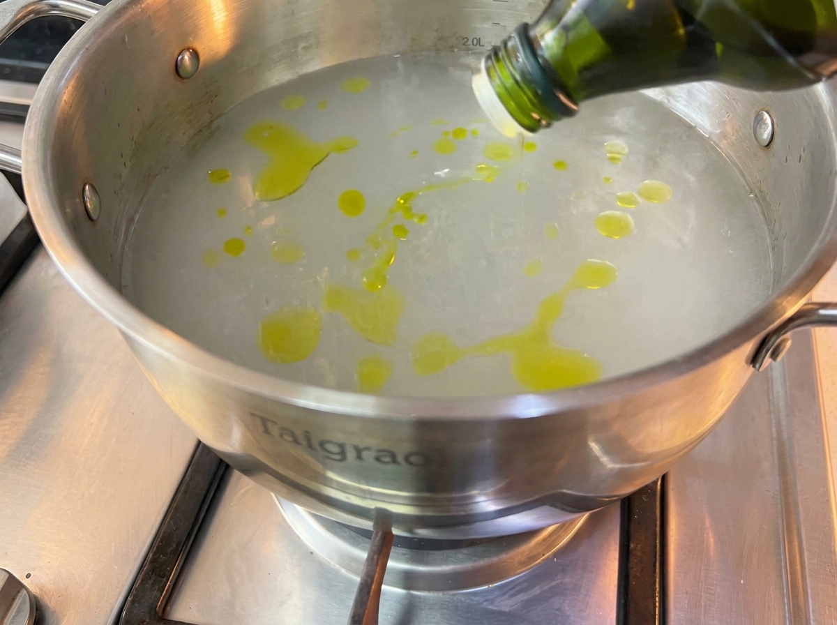 Des spaghettis secs plongés dans une grande casserole deau bouillante.