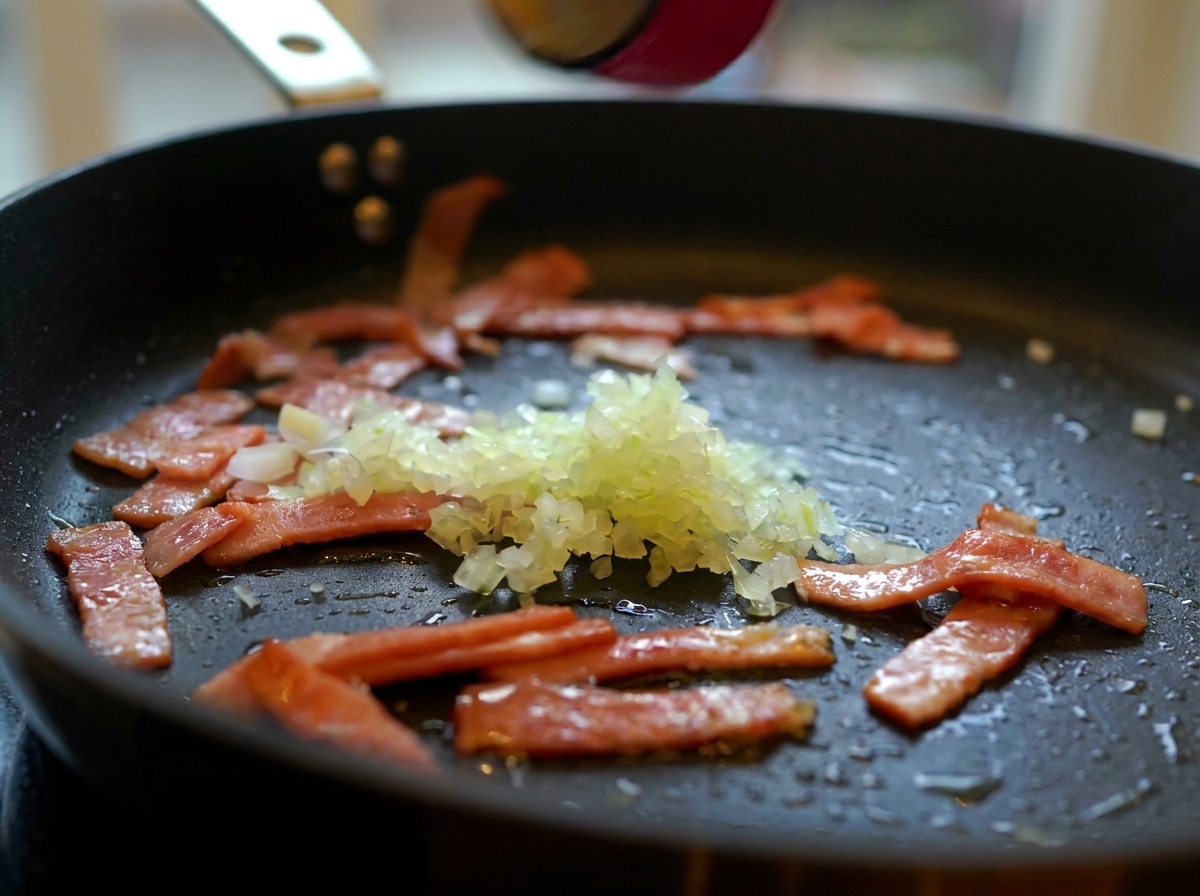 Des oignons hachés, de lail et des champignons émincés ajoutés à la poêle avec les lardons dorés.