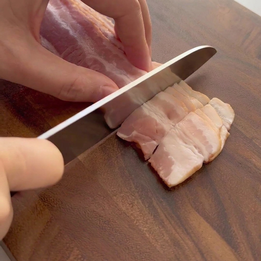 Tranches de bacon cru découpées sur une planche en bois.