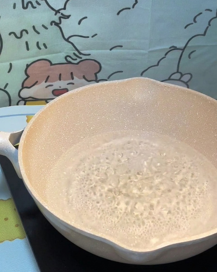 Pâtes sèches plongées dans une casserole deau bouillante frémissante.