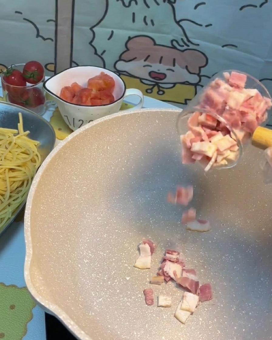 Morceaux de bacon grésillant et dorant dans une poêle chaude.