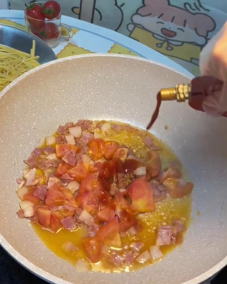 Sauce soja, sauce tomate et sucre versés dans la poêle avec le bacon et les tomates.