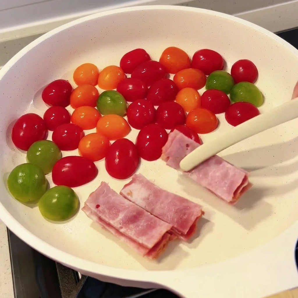 Tranches de bacon cru ajoutées dans la poêle avec les tomates.
