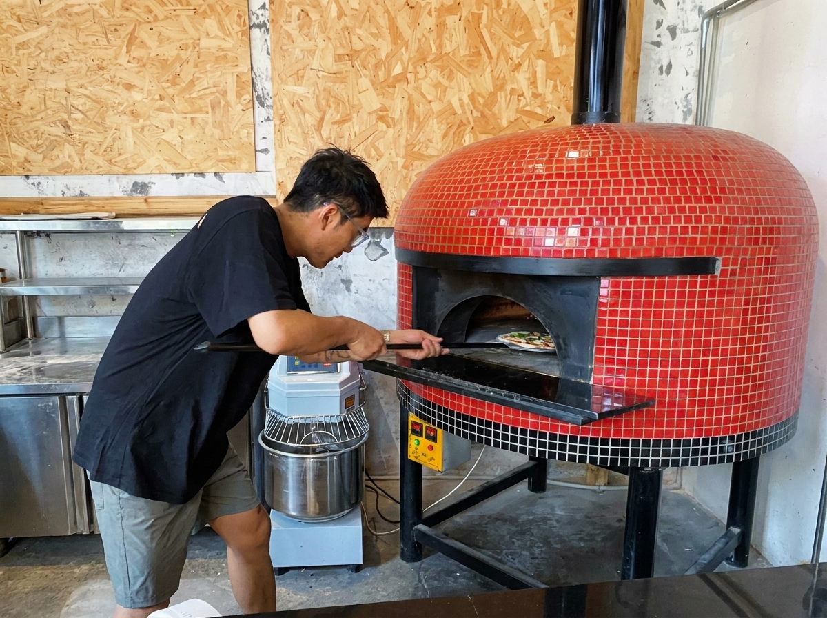 Une pizza enfournée dans un four à bois à laide dune pelle.