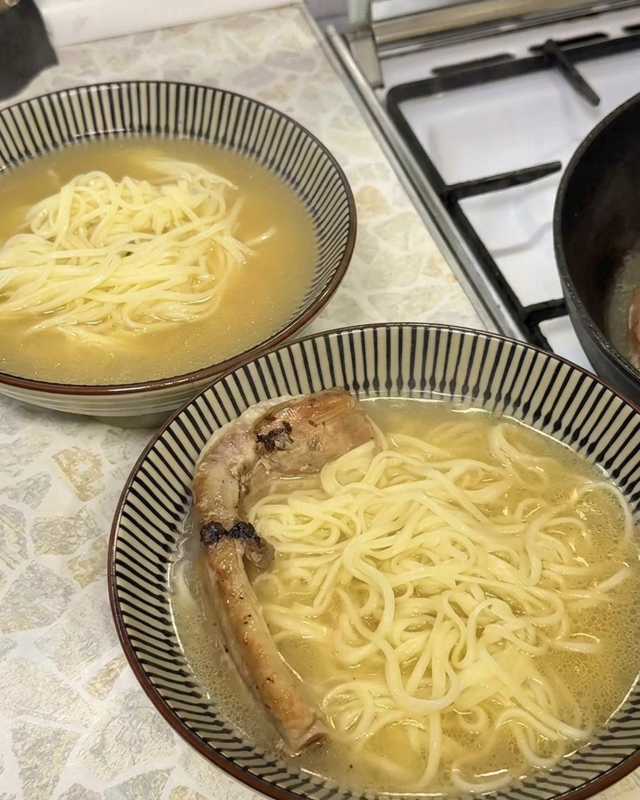 Gros plan sur un travers de porc braisé doré et tendre placé dans un bol de ramen.