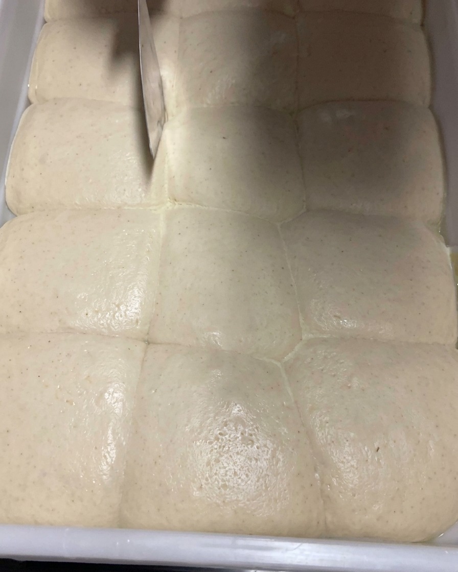 Gros plan dune pâte fermentée divisée en portions à laide dune coupe-pâte.