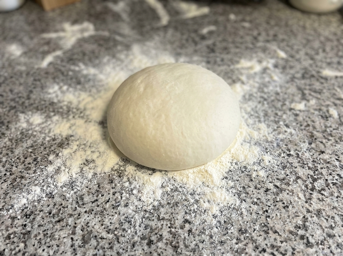Pâte pressée et façonnée en cercle sur un plan de travail fariné.