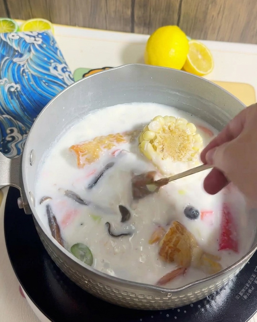 Nouilles ramen ajoutées dans la casserole avec le bouillon crémeux.
