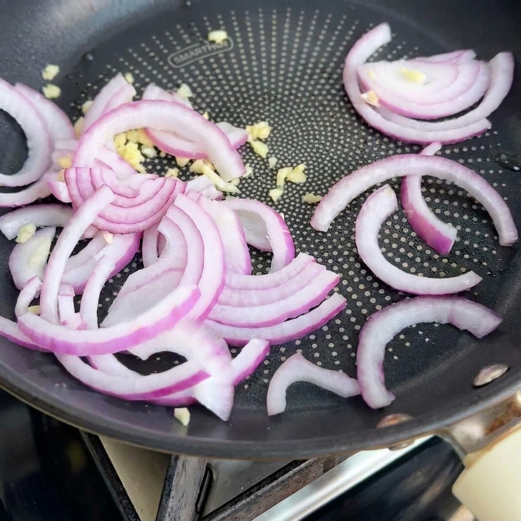 Oignons et ail sautant dans une poêle avec du beurre.