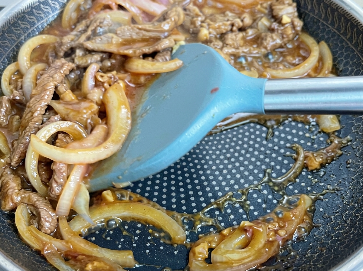 Bœuf et oignons mijotant dans une sauce brillante.