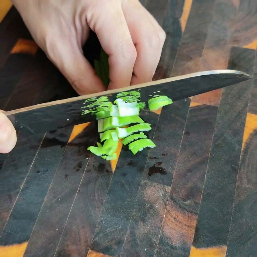 Feuilles de moutarde marinées hachées sur une planche à découper en bois.