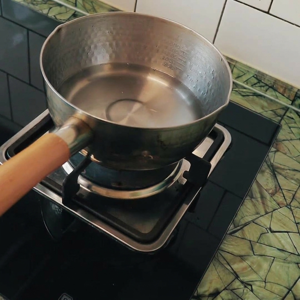Des cubes de tofu ajoutés dans une casserole deau bouillante.