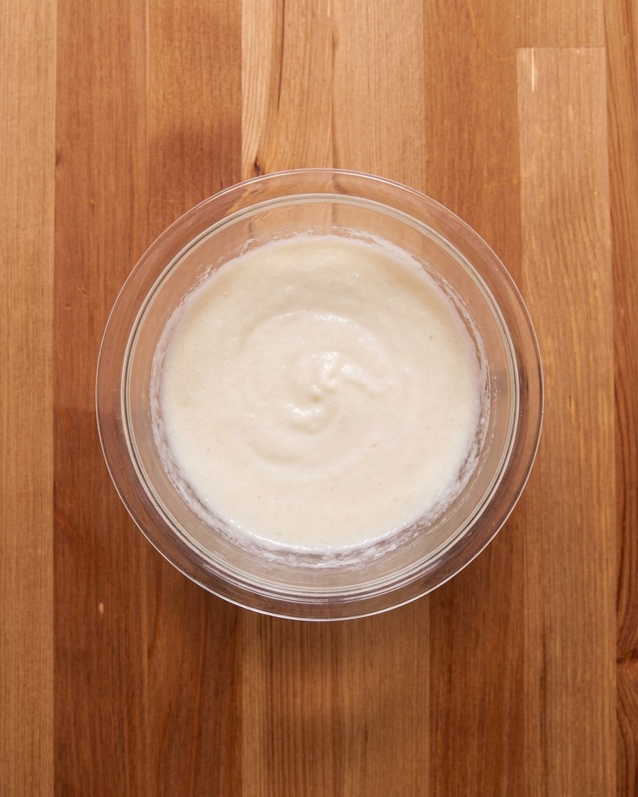 La pâte digname blanche et le bouillon de viande mélangés dans un bol en verre.