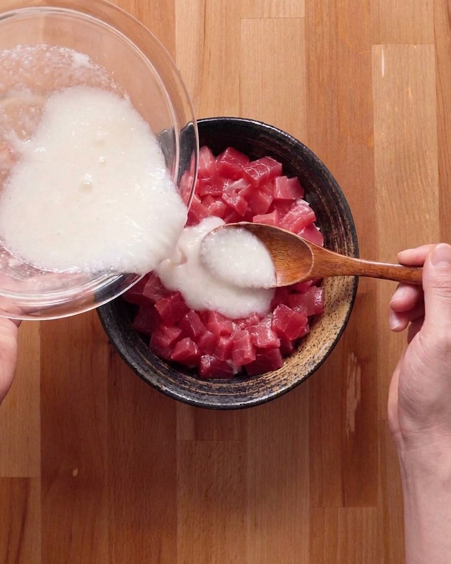 Le mélange blanc digname et de bouillon versé sur le bol de thon et de riz.