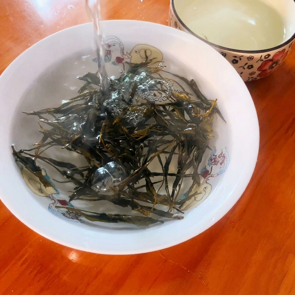 De leau bouillante versée sur des feuilles de thé vert sèches dans un petit bol décoratif.