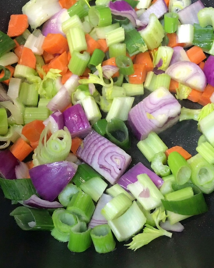 Légumes en dés sautés dans une poêle chaude.