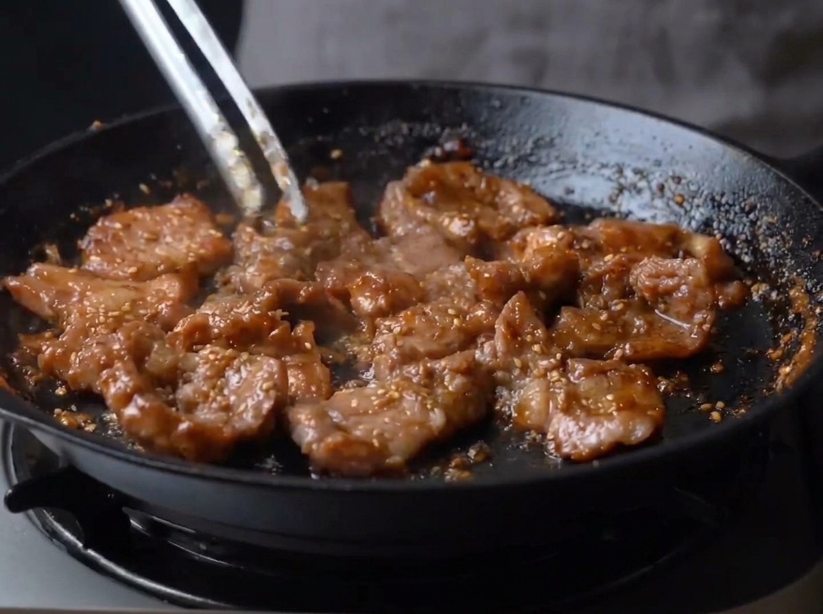 Bouchées de porc enrobées dun glaçage brun brillant dans la poêle.