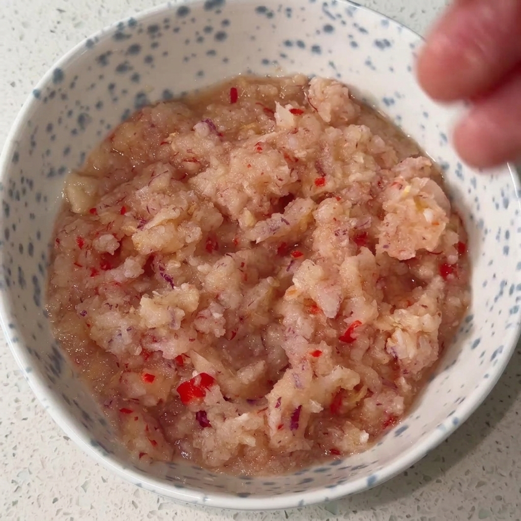Bol contenant la base mixée doignon et de piment, mélangée aux autres assaisonnements pour créer une riche sauce rouge.
