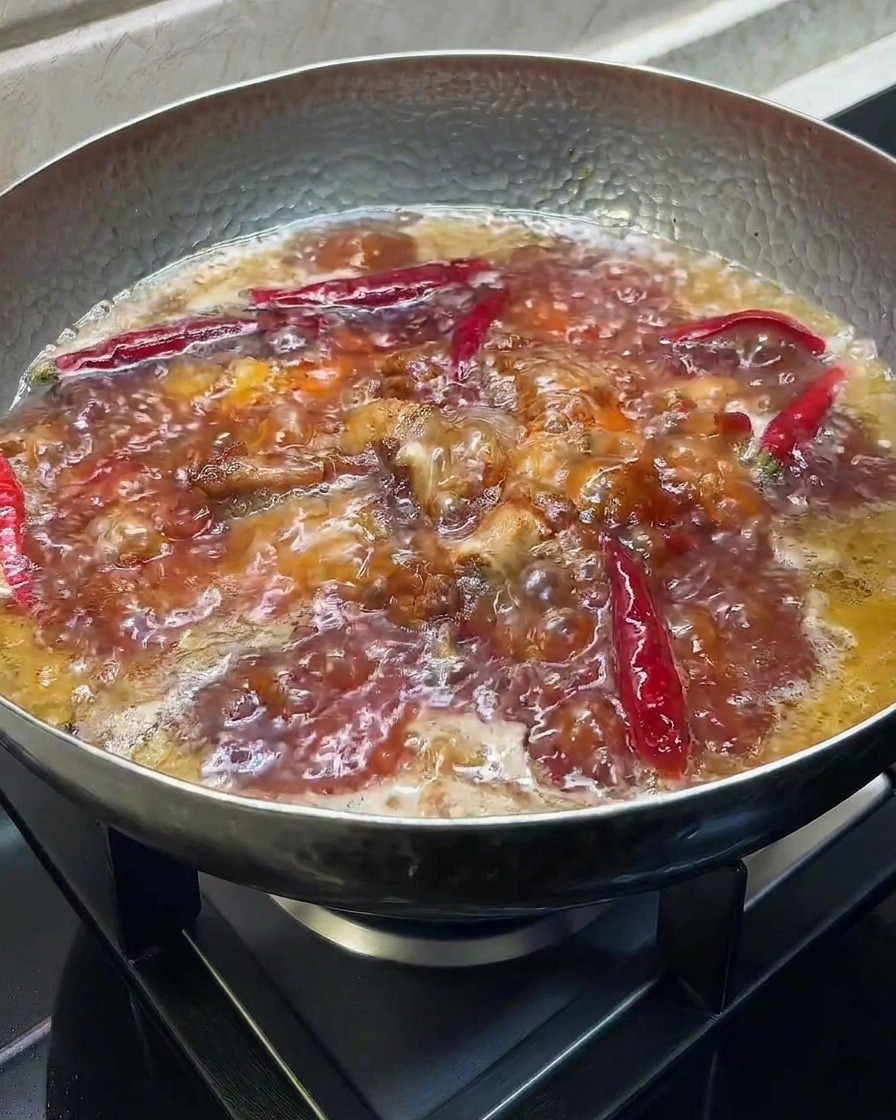 Sauce soja noire et vinaigre ajoutés à une marmite de travers de porc en bouillon.