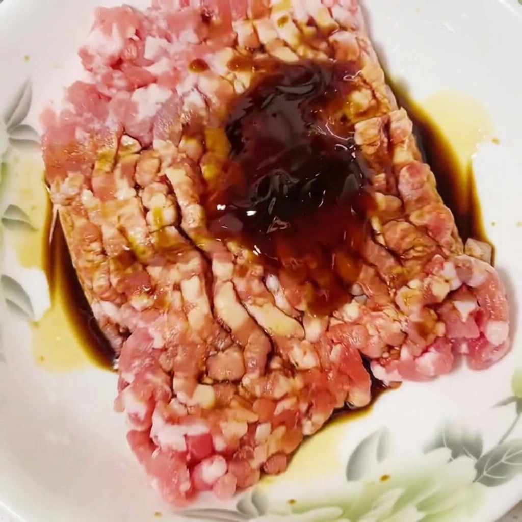 Essence de poulet saupoudrée sur le mélange de viande crue.