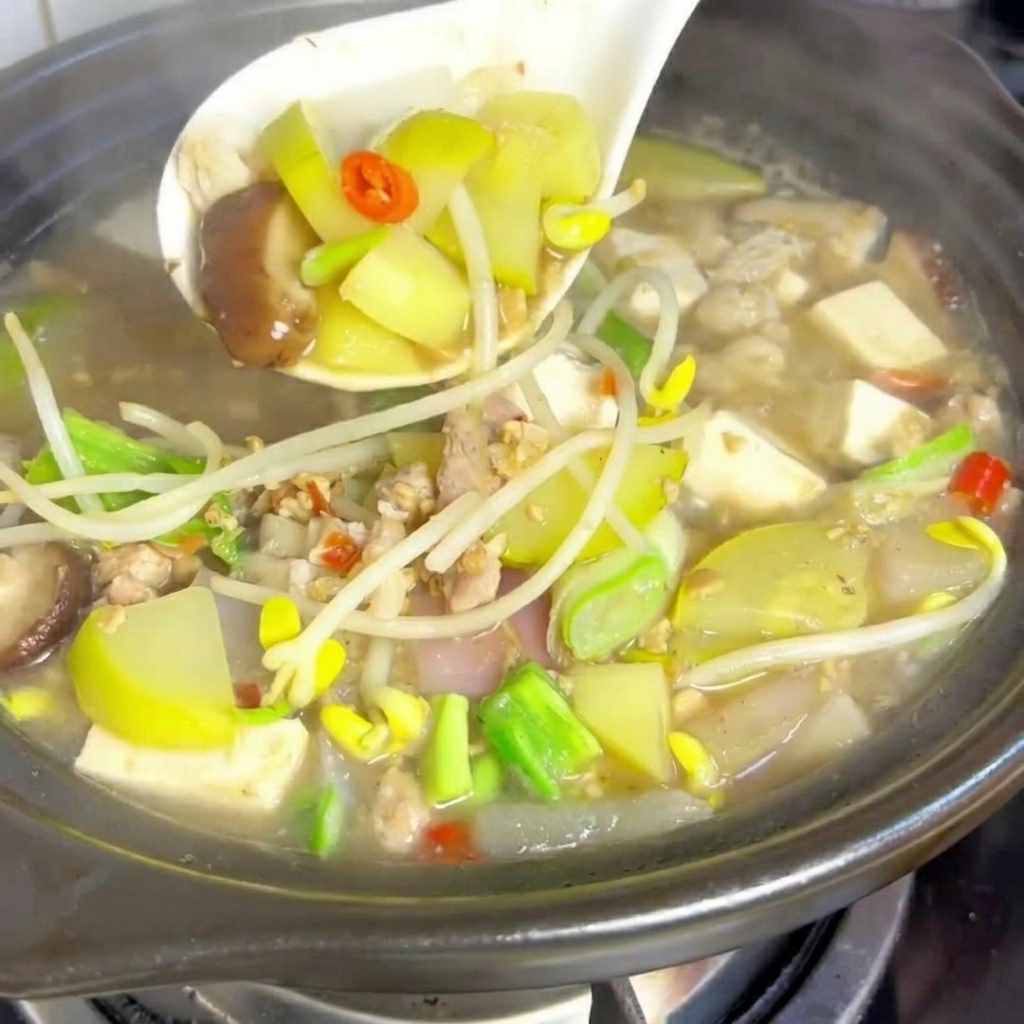 Cubes de tofu soyeux placés dans la marmite de ragoût frémissant.