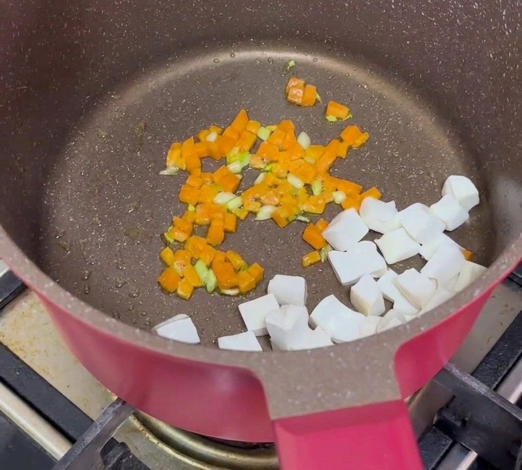 Cubes de tofu, bœuf haché cuit et carottes sautées combinés ensemble dans une poêle.