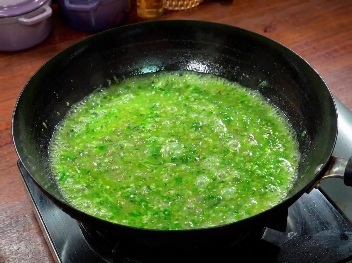 Des lamelles de bœuf cuisant dans un bouillon épicé vert vif à lintérieur dun wok.