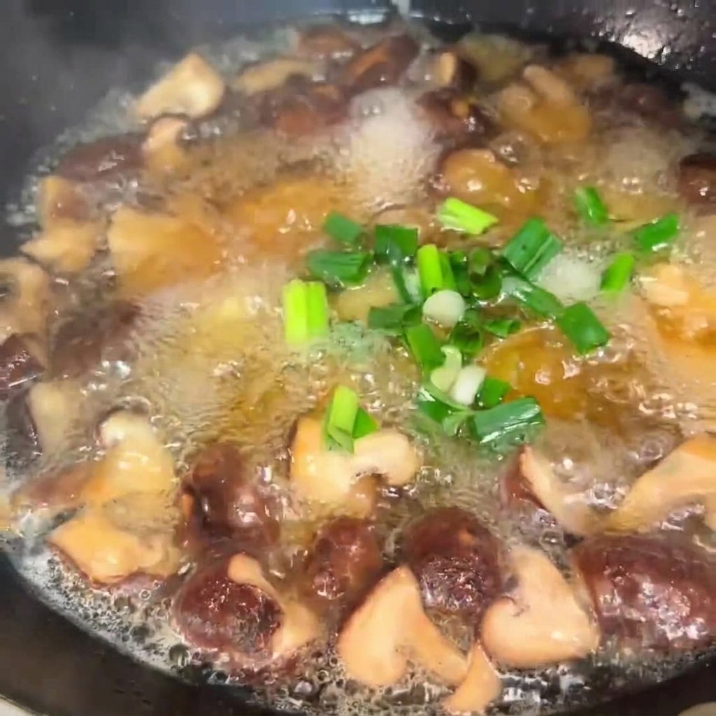 Oignons verts hachés saupoudrés dans une casserole bouillonnante de soupe aux champignons et au tofu.