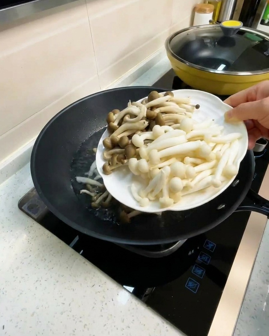 Champignons hêtre et champignons saveur crabe ajoutés dans le bouillon bouillant du wok.